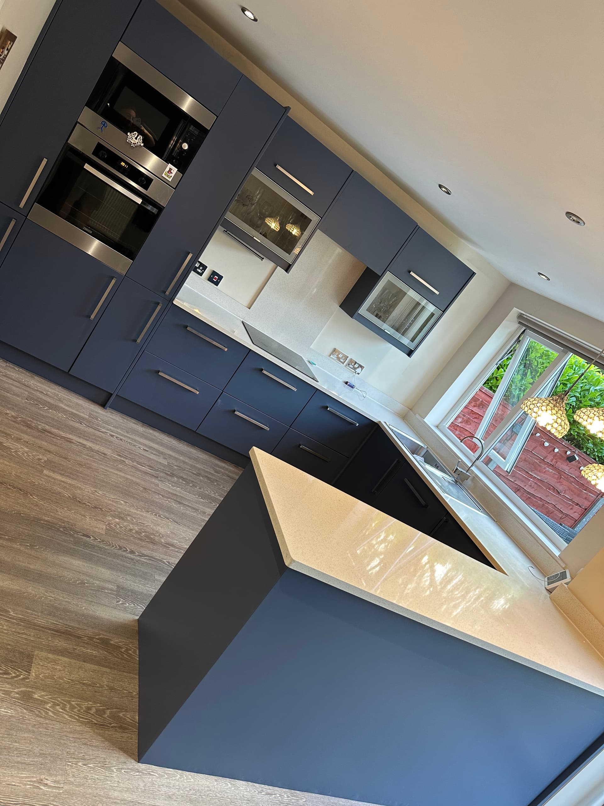 Professional kitchen respray - white to navy blue transformation with island - Revitalize Resprays Manchester